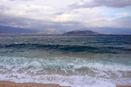 Waves crashing against sandy beach on a stormy afternoon in Dalmatia, Croatia.の写真素材