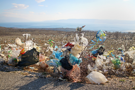 Discarded plastic shopping bags from an unguarded garbage disposal facility, polluting meadows on a hill slope in Croatia.のeditorial素材