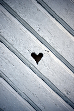 Heart shaped hole in wooden shutterの写真素材