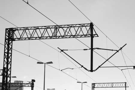 Railway traction. Electricity pylons and power lines against the sky. Black and white photo