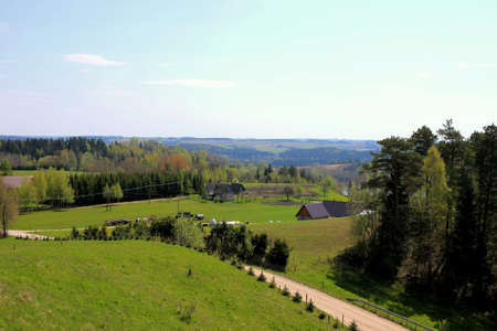 The landscape of the Suwalki Region. Top view of farmland and farms. Polish countryside. Green meadows, houses and gravel roadの写真素材
