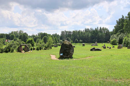 Huge erratic boulders in the megalith park. Big stones lie in the green grass. There are green trees around. Silvarium, a forest park in the Poczopek, the Krynki Forest District. Podlasieの写真素材