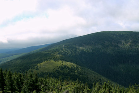 Karkonosze in the summer. View of the mountains covered with green trees. Thick clouds over the mountains. Karkonosze National Parkの写真素材