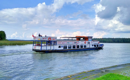 The passenger ship "Serwy", belonging to the Augustow Shipping, sails along the Augustow Canal. Cloudy sky. September 2021, Augustowのeditorial素材