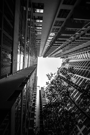 Low angle shot of modern glass city buildings with clear sky background.