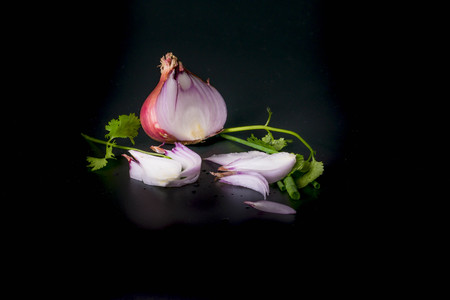 Onion decorated parsley leaves on black backgroundの写真素材