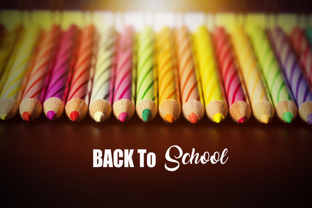 Concept of School holiday  with inscription, color pencils on black background with flare.の写真素材