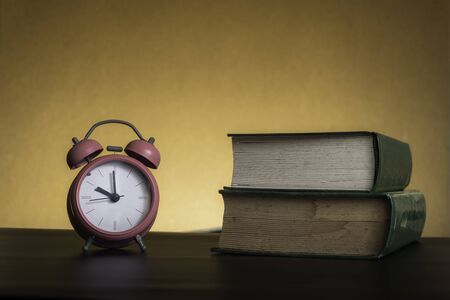 Symbolic hard study is powerful to succeed, concept with book and alarm clock. Time in business and qualityの写真素材
