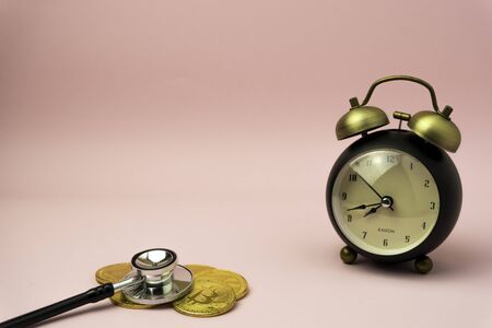 Time to make money concept, pink retro styled alarm clock on heap of american dollars. Banking,...