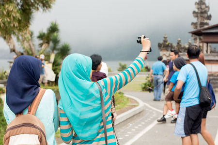 Two young Muslim women taking selfie, view from the backのeditorial素材