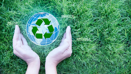 Earth Day.Female hand holding globe and sign of recycling on green grass background. Ecology and...