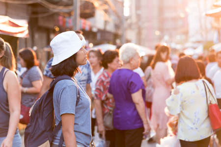 Young Woman traveling Asian traveling backpacker in evening at Khaosan Road outdoor market in Bangkok, Thailand, traveler and tourist concept,  landmark and popular for tourist attractions in Thailand.の写真素材