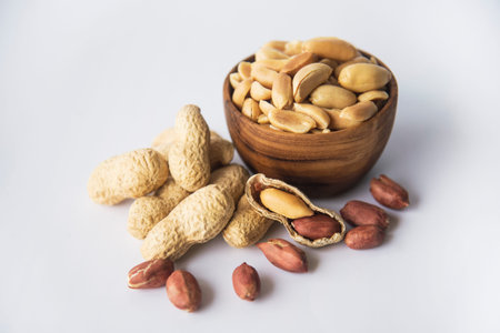 Peanuts  in  wooden bowls a collection of whole peanuts in their shells and a few without...