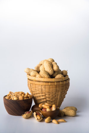 Peanuts in basket a collection of whole peanuts in their shells and a few without shells,healthy snacking concept with peanuts rich in protein, isolated on white background.の写真素材