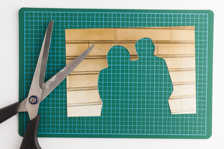 Photograph with cut out people with scissors on green cutting mat signifying missing people and...