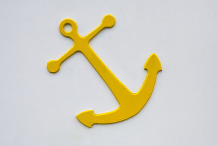 Yellow anchor on white wall at seaside in Scarborough, United Kingdom, Yorkshireの写真素材