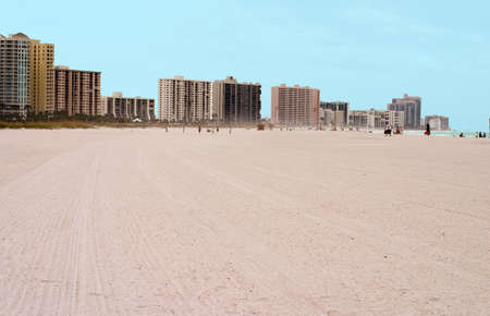 Sandy beach backdropped by city buildingsの写真素材