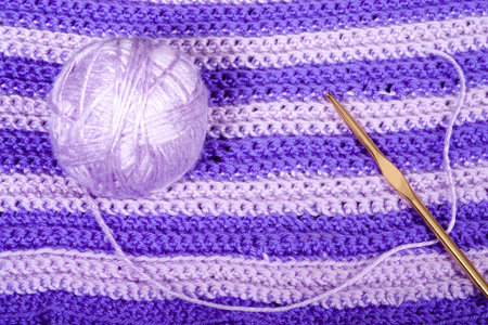 Crochet yarn and hook on crocheted backgroundの写真素材