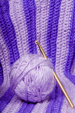 Ball of yarn and crochet hook on crocheted backgroundの写真素材