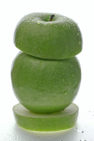 Close up of tower made of two green apples, isolated on whiteの写真素材
