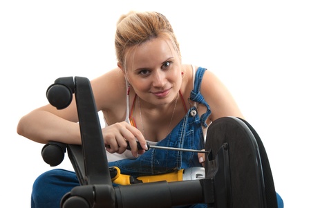 Young girl repairs broken plastic chair isolated on whiteの写真素材