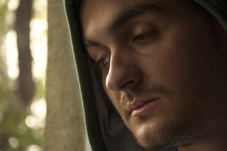 Portrait of young worried man looking through window