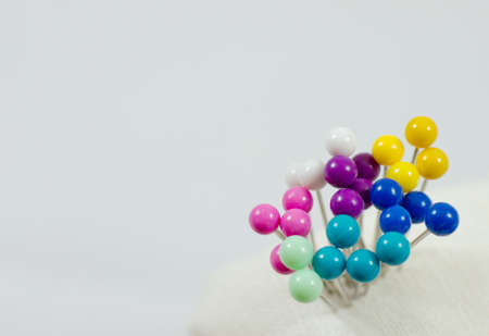 Colorful straight pins, view from top on a white background の写真素材