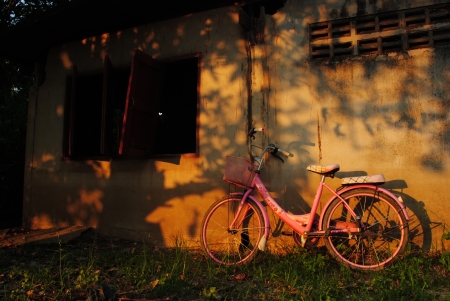 Old bicycle leaning against grungy barnの写真素材