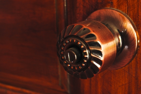Color photo of a metal handle on a wooden doorの写真素材