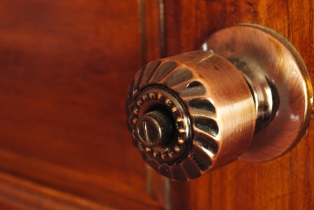 Color photo of a metal handle on a wooden doorの写真素材