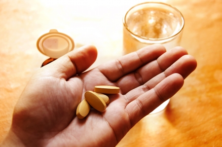 Pills spilling from a bottle into a hand の写真素材