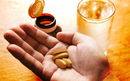 Pills spilling from a bottle into a hand の写真素材