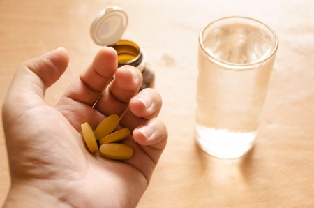 Hand holding yellow pillsの写真素材