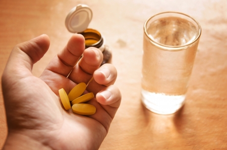 Hand holding yellow pillsの写真素材