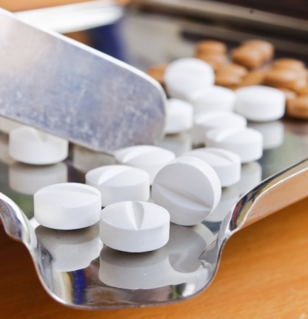 Close up of Counting tablets medical pills on stainless steel tray.(Health care and medical concept)の写真素材
