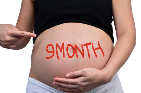 Pregnant women with the inscription "9 month "の写真素材
