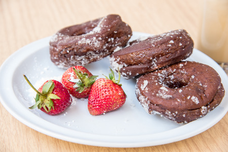 Sugar chocolate donuts and fresh strawberries and ice coffeeの写真素材