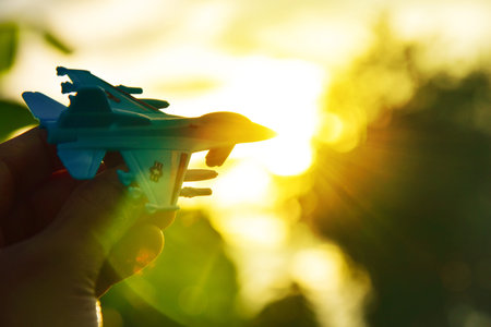 Success concept Airport, Holding toy Airplane in the sky at sunset. Flying to the sky