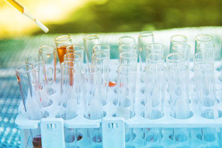 Lab science research glass items adding drop to one of several test tubes. A scientific experiment...