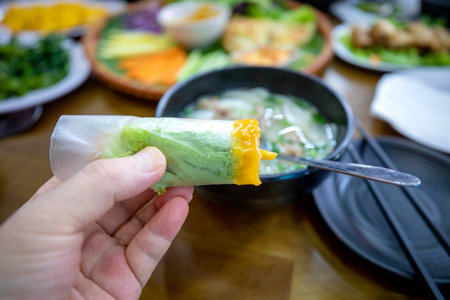 Hand holding a piece of vegetable salad with sweet and sour sauce.