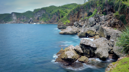 beautiful view of the south coast of Yogyakarta, this beach is called beach Butuh. has white sand, steep cliffs, and blue sea waterの写真素材