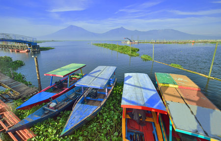 Rawa Pening - The lake is on the slopes of the mountain, the boat is leaning against the dock, the boat is on the shore of the lakeの写真素材