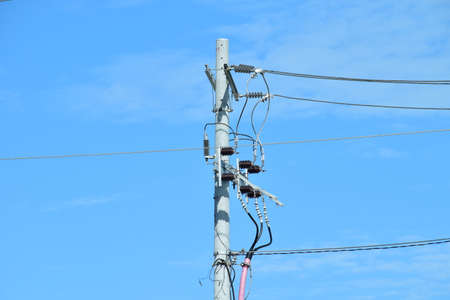 High-voltage electricity, Power poles against a blue sky backgroundの写真素材