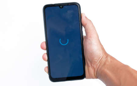 Display loading on the smartphone screen. Hand holding handphone in white backgroundの写真素材