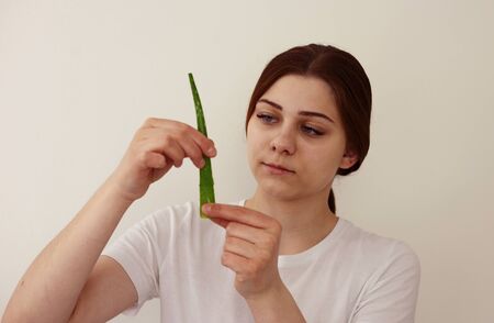 Young woman holds leaf of aloe veraの写真素材