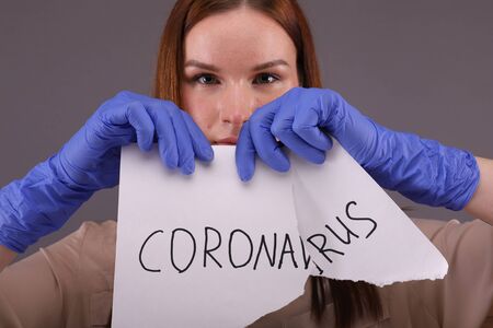 End of pandemic. Woman tears the sign "coronavirus"の写真素材