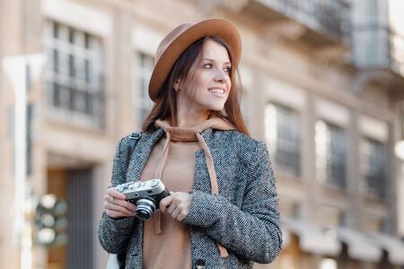 A young girl looks around, smiles and looks for something to photograph. Girl close-up.の写真素材