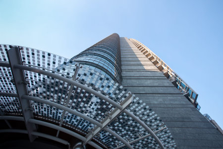 Gray high multi-storey office building with a geometric pattern in blue and blue against a blue sky....