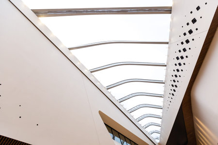 A huge ceiling in a modern style with large windows combined with white wood