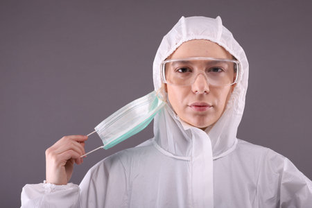 Woman in protective costume takes off a mask